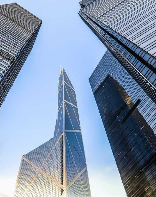 A low angle view of tall buildings in a metropolitan area. The buildings appear to be skyscrapers and corporate headquarters, and the image captures the urban cityscape against the sky.