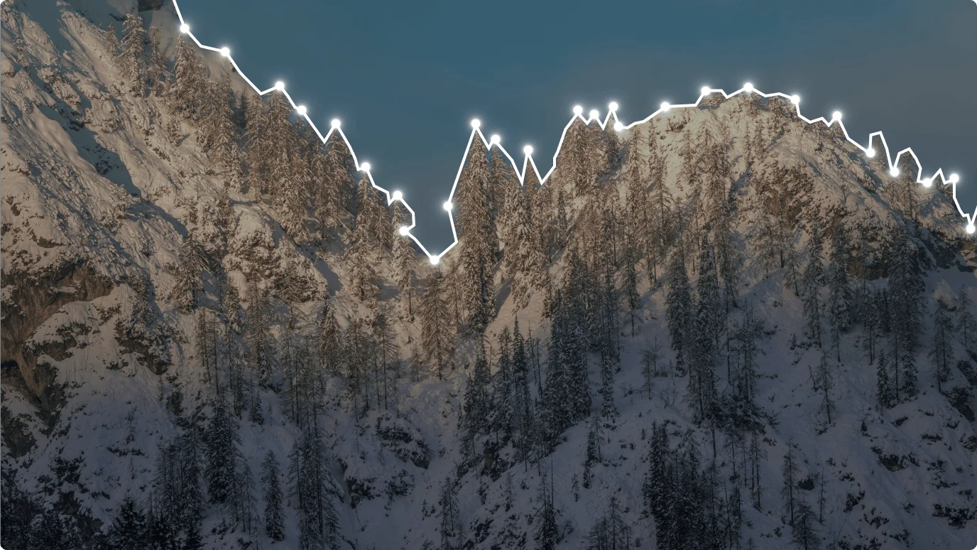 A snow-covered mountain with trees in a scenic outdoor winter landscape.