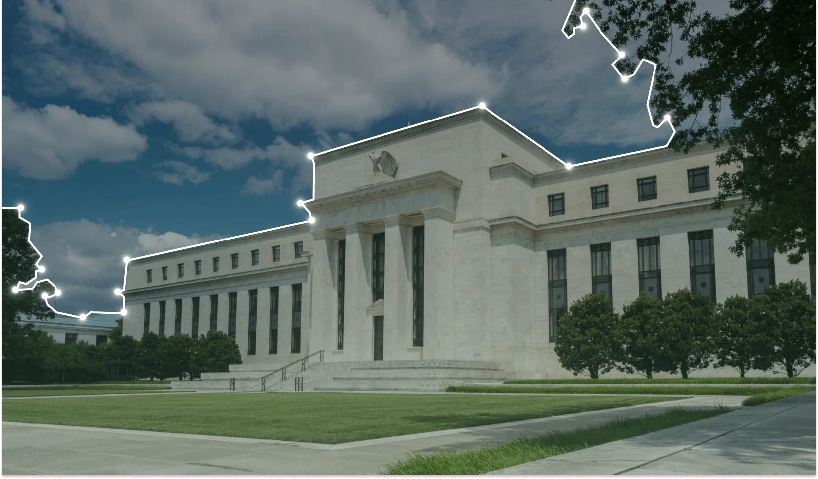 a large white building with columns, set against a backdrop of clouds and trees. It appears to be an outdoor government building or courthouse with a grassy area in front of it.