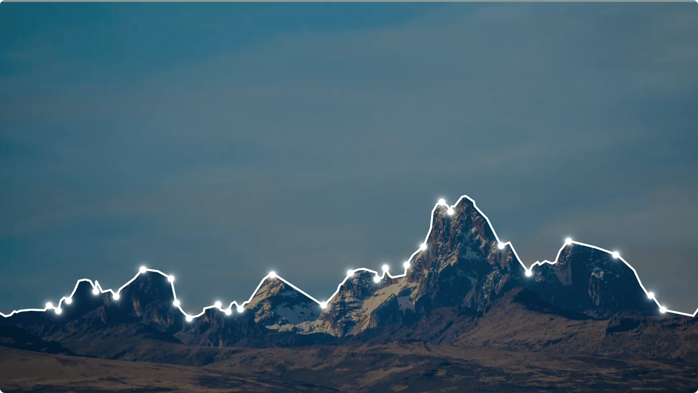 A group of snow-covered mountains. The landscape features a cloudy sky and a glacial terrain.