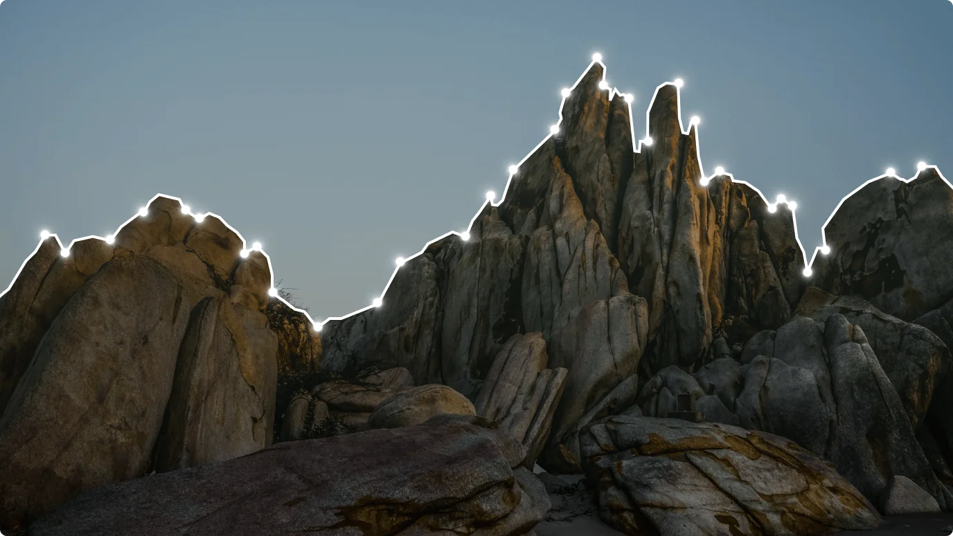 A rocky mountain set against a clear blue sky. The landscape showcases natural rock formations and a striking outdoor scene.
